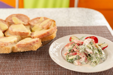 Green vegetables salad. Tomatoes, cucumbers, onions, parsley, fennel, sour cream, bread, sandwiches. A table in summer cafe.