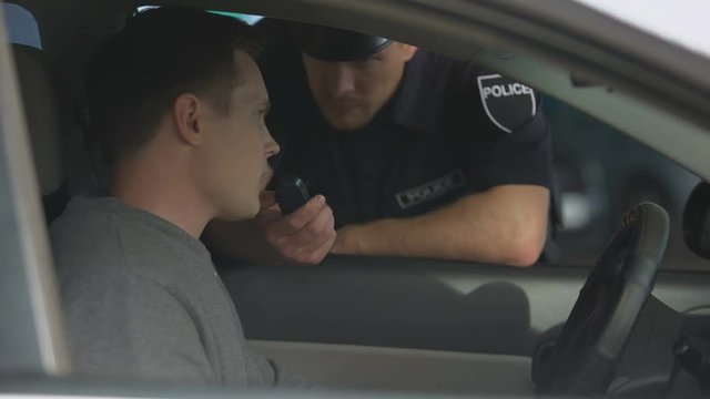 Male driver passing alcohol test, negative result, police traffic control