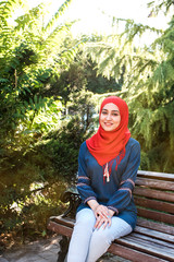 Fototapeta premium Beautiful young arabic girl in hijab posing for a camera at summer street.