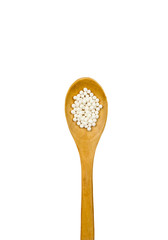 Wood spoon with small white round homeopathy pills isolated on white background, copy space.