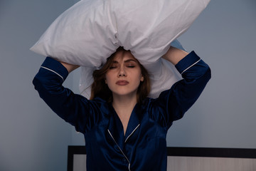 Stressed woman in the bed holding a pillow on her hand