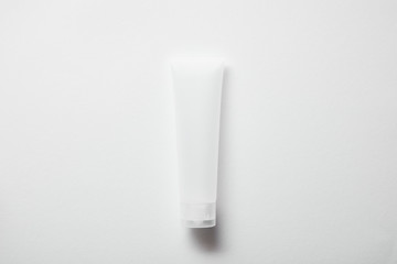 top view of empty plastic cream tube on white