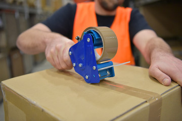 workers in a goods warehouse in the retail trade packaged a package with adhesive tape