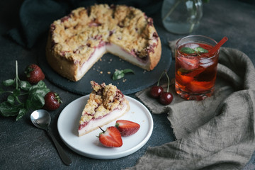 Summer dessert. Rustic berry cake with a delicate souffle and strawberry homemade lemonade on a dark background.