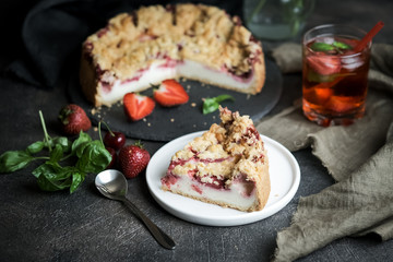 Summer dessert. Rustic berry cake with a delicate souffle and strawberry homemade lemonade on a dark background.