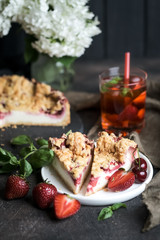 Summer dessert. Rustic berry cake with a delicate souffle and strawberry homemade lemonade on a dark background.