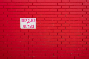 Fototapeta premium painted red brick wall and sign