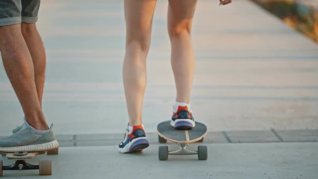 Young woman and man riding skateboard - riding on the waterfront