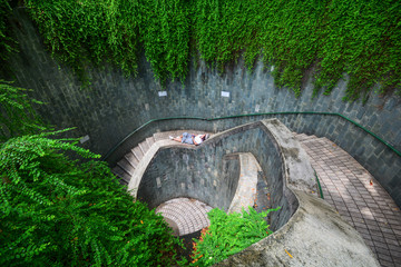 A young asian woman  tourist sat  standing on the staircase at Underground spiral staircase at Fort...