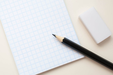 Notebook with a place for an inscription and a black pencil on a neutral background
