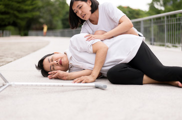 Senior asian woman lying unconscious and suffering from heart attack outdoor,Daughter take care and...
