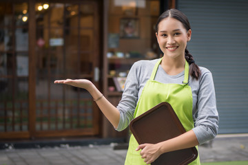 Young shop manager, small business owner, woman entrepreneur pointing up © 9nong
