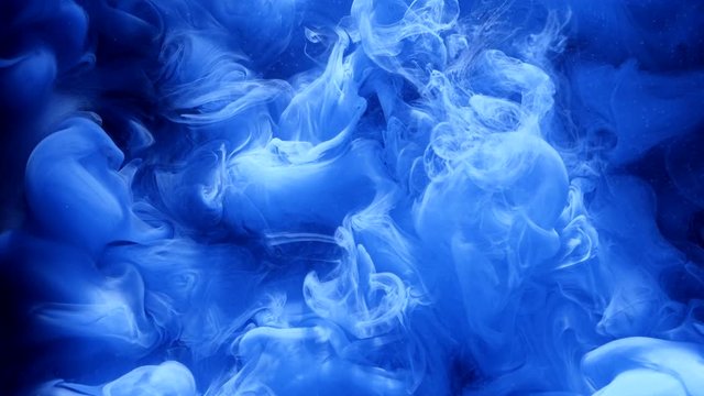 Underwater ink explosion. Dye mixing and blending.Blue smoke swirling