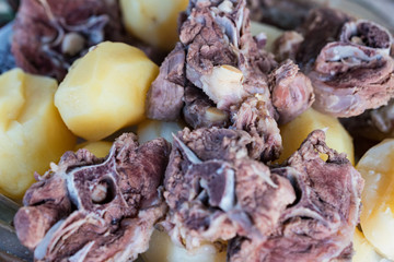 Boiled lamb meat and whole potatoes close up