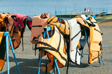 Life jackets on the shore. Safety boat trips.