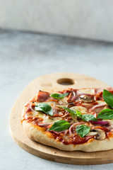 Pizza with ham and mushrooms on light background.