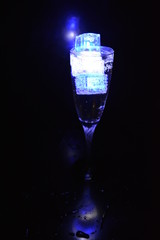 Very beautiful and stunning images of drinks with glowing ice cubes.  Bright colors with bubbles in a glass of champagne.  Promotional image of a relaxing, dear life and a tasty sparkling drink.