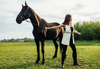 Buttom view of beautiful woman and expensive breed hourse. Outdoor shot, sport and fashion concept.