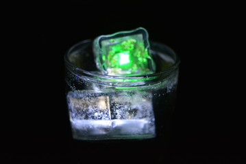 Very beautiful and stunning images of drinks with glowing ice cubes.  Bright colors with bubbles in a glass of champagne.  Promotional image of a relaxing, dear life and a tasty sparkling drink.