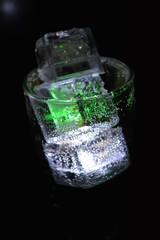 Very beautiful and stunning images of drinks with glowing ice cubes.  Bright colors with bubbles in a glass of champagne.  Promotional image of a relaxing, dear life and a tasty sparkling drink.