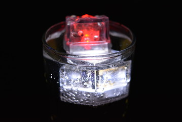 Very beautiful and stunning images of drinks with glowing ice cubes.  Bright colors with bubbles in a glass of champagne.  Promotional image of a relaxing, dear life and a tasty sparkling drink.
