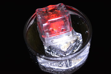 Very beautiful and stunning images of drinks with glowing ice cubes.  Bright colors with bubbles in a glass of champagne.  Promotional image of a relaxing, dear life and a tasty sparkling drink.
