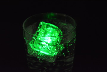 Very beautiful and stunning images of drinks with glowing ice cubes.  Bright colors with bubbles in a glass of champagne.  Promotional image of a relaxing, dear life and a tasty sparkling drink.