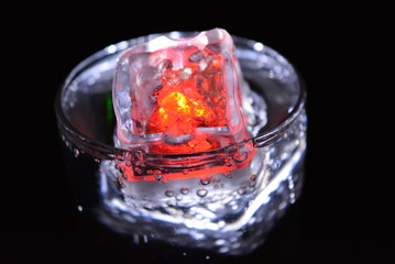 Very beautiful and stunning images of drinks with glowing ice cubes.  Bright colors with bubbles in a glass of champagne.  Promotional image of a relaxing, dear life and a tasty sparkling drink.