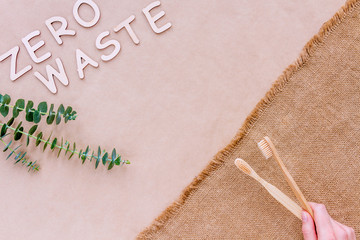 Reusable recyclable sustainable wooden toothbrush isolated on brown craft fabric background. Refuse, reduce, recycle and zero waste concept. Ecology, cut plastic footprint.