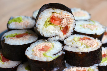 Stack of rolled Maki sushi with tuna, tomatoe and salad 