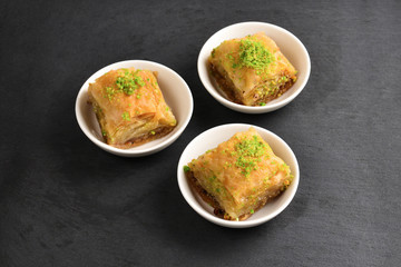 Pistachio baklava on a black plate. Dessert.
