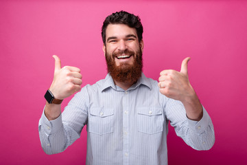 Cheerful bearded man in casual showing thumbs up gesture