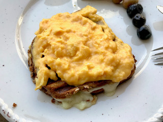 Homemade Creamy Scrambled Eggs in Breakfast Plate with Toast Bread.