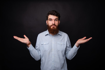 I don't know! Young bearded man gesturing with both hands he doesn't know.