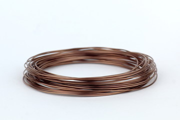 Naklejka premium Coil of wire with a hint of copper, bronze on a light background.