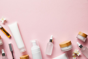 top view of cream tubes, cosmetic dispenser, empty jars and with hand cream, mascara bottles on pink - obrazy, fototapety, plakaty