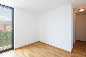 Empty white room with light parquet and window overlooking Lake Maggiore