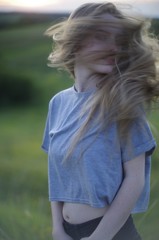  beautiful young blonde with long flowing hair on a blurred background of summer greenery