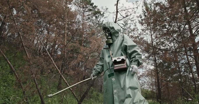 Person in WWII Hazmat suit and mask in a forest