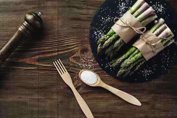 Fototapeta na wymiar An edible, raw stems of asparagus on a wooden background.
