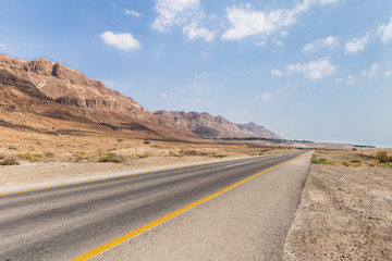 Fototapeta na wymiar Panoramic view of the road, coast of Dead Sea and mountains in the Judean Desert in the Dead Sea region in Israel