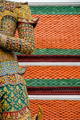 Detail of whole decorated warrior figure with roof in background, in Buddhist temple, Bangkok, Thailand