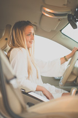 Pretty, young woman  driving a car -Invitation to travel. Car rental or vacation.