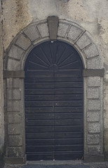 stone arched entrance of a medieval building. San Giulio Island, Italy.