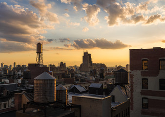 Summer Sunset light on Chelsea rooftops, the Walker Tower, and water towers. Manhattan, New York City