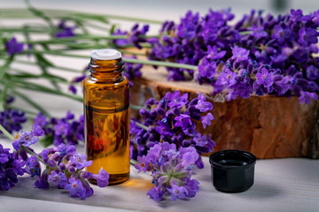 Obraz na płótnie Canvas lavender essential oil bottle with fresh flowers