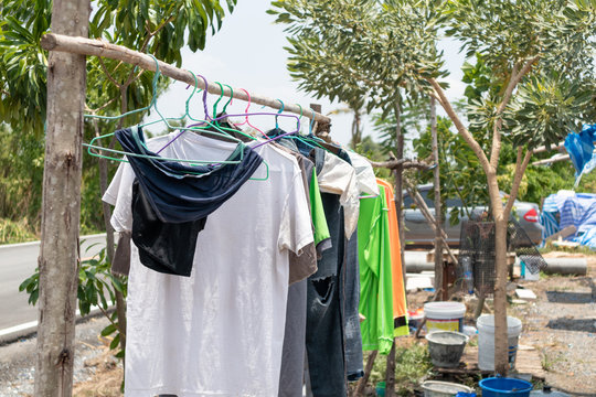 Dry clothes hanging on wooden clothes rack after washing clothes in camping outdoor. Washing and Cleaning concept.