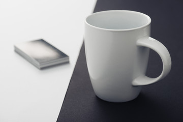 white coffee cup and stack of business cards on black and white background