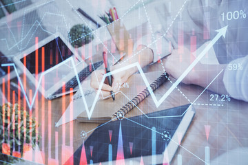 Financial graph displayed on woman's hand taking notes background. Concept of research. Double...
