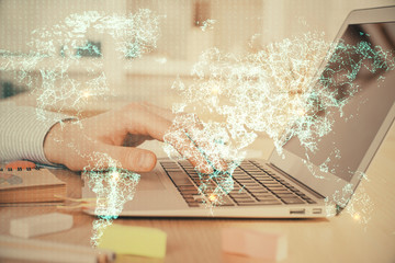 Social network theme hologram with businessman working on computer on background. Concept of world...